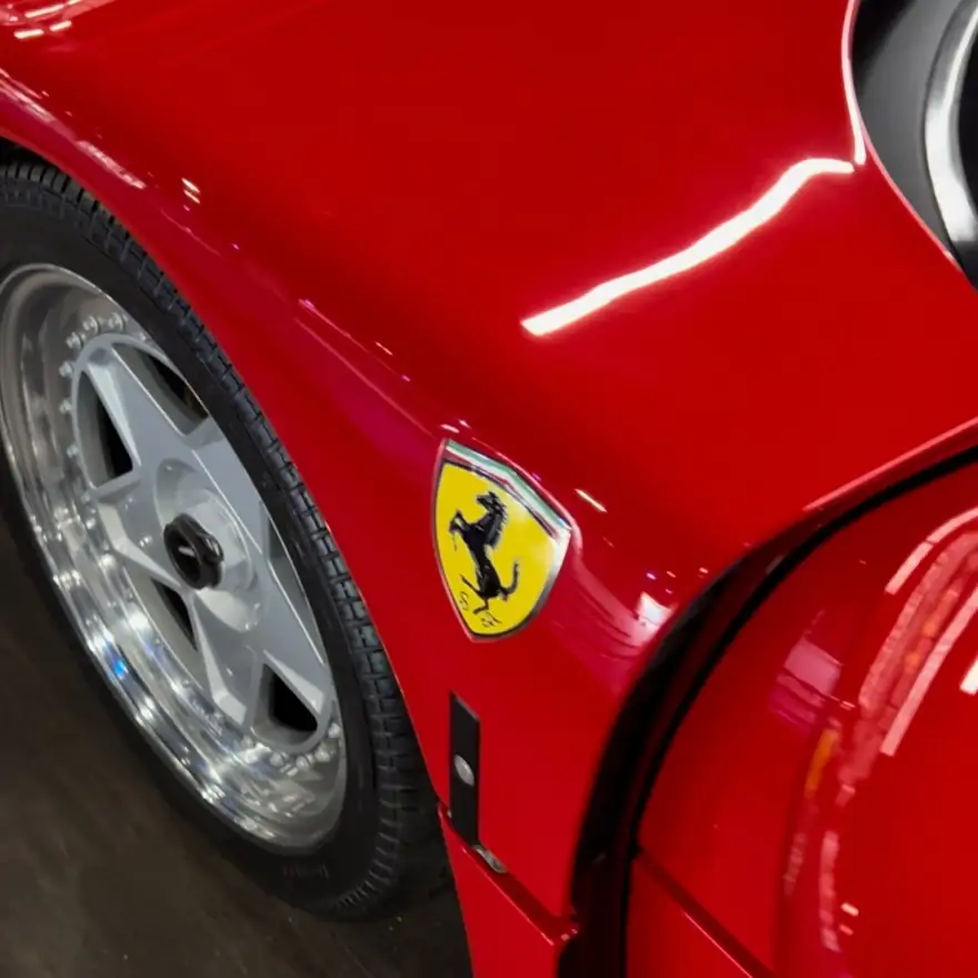 Close-up of a red Ferrari front fender and wheel after paint correction