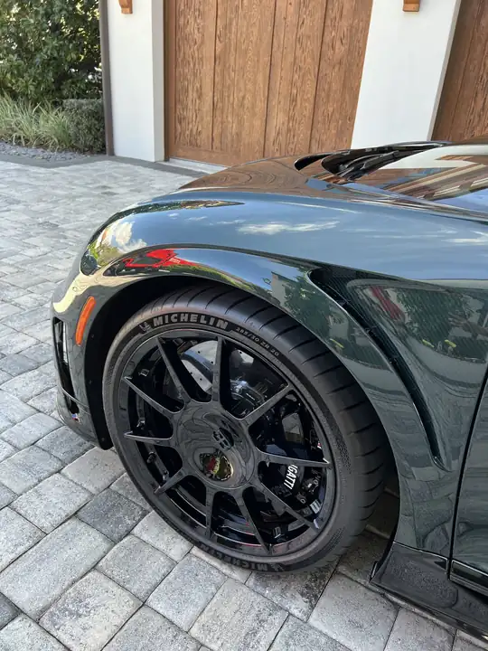 A dark Lamborghini with a mirror-finish rear quarter panel